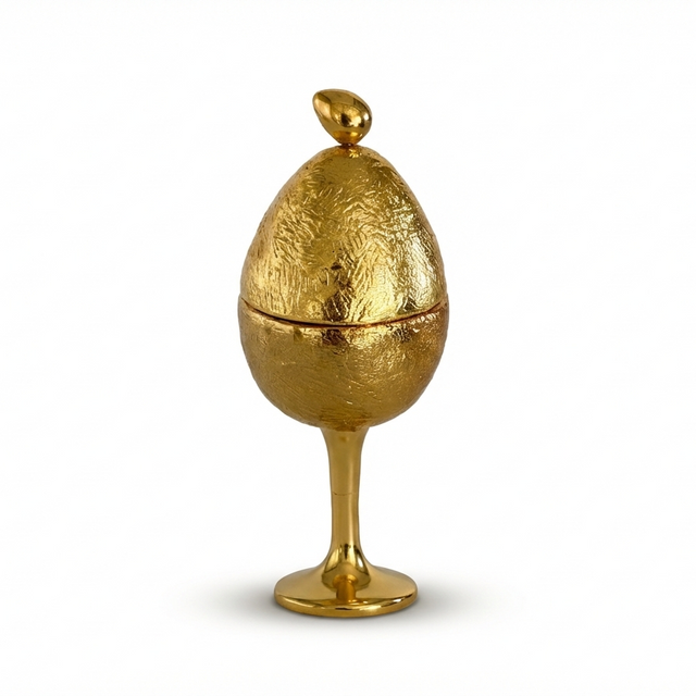 Gold egg-shaped decorative item on a white background