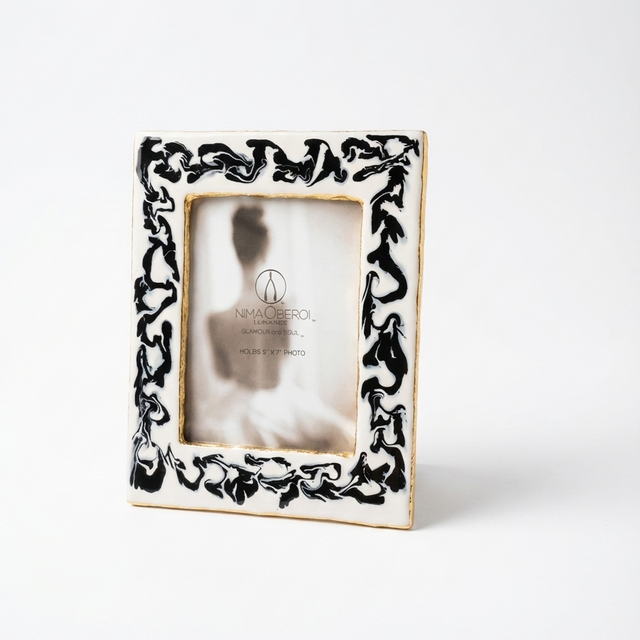 Decorative photo frame with black leaf pattern on a white background