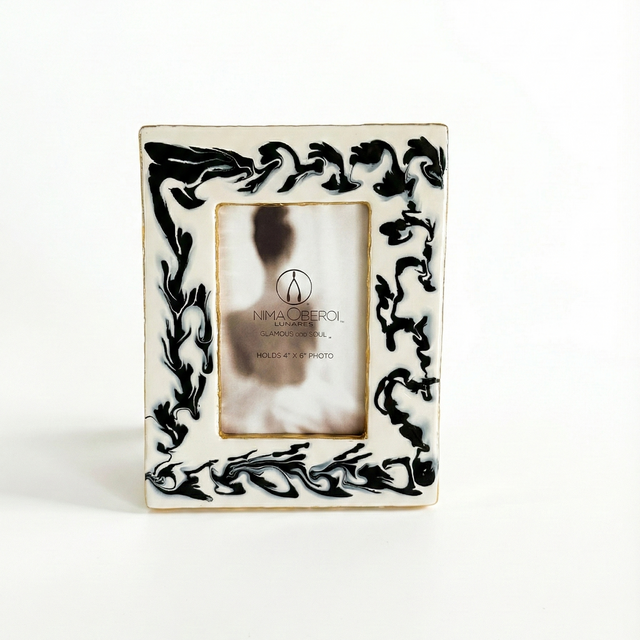Decorative picture frame with black floral patterns on a white background