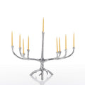 A silver tree-branch style candelabra with nine candle holders, shown with nine lit yellow taper candles on a clean white background.