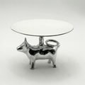 Small round table with a glass top and metallic cow-shaped base on a white background