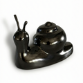 Metallic snail sculpture on a white background