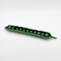 Green ceramic pea pod with peas on a white background