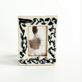 Decorative picture frame with black floral patterns on a white background
