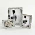 Three silver photo frames with different sizes on a white background